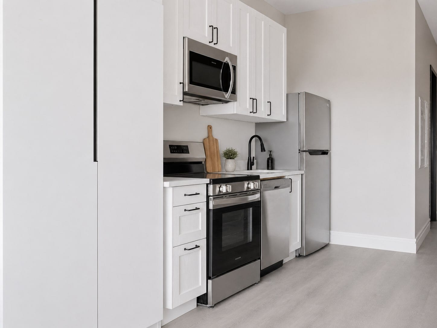Suite kitchen with a range, dishwasher, over-range microwave and full-height fridge