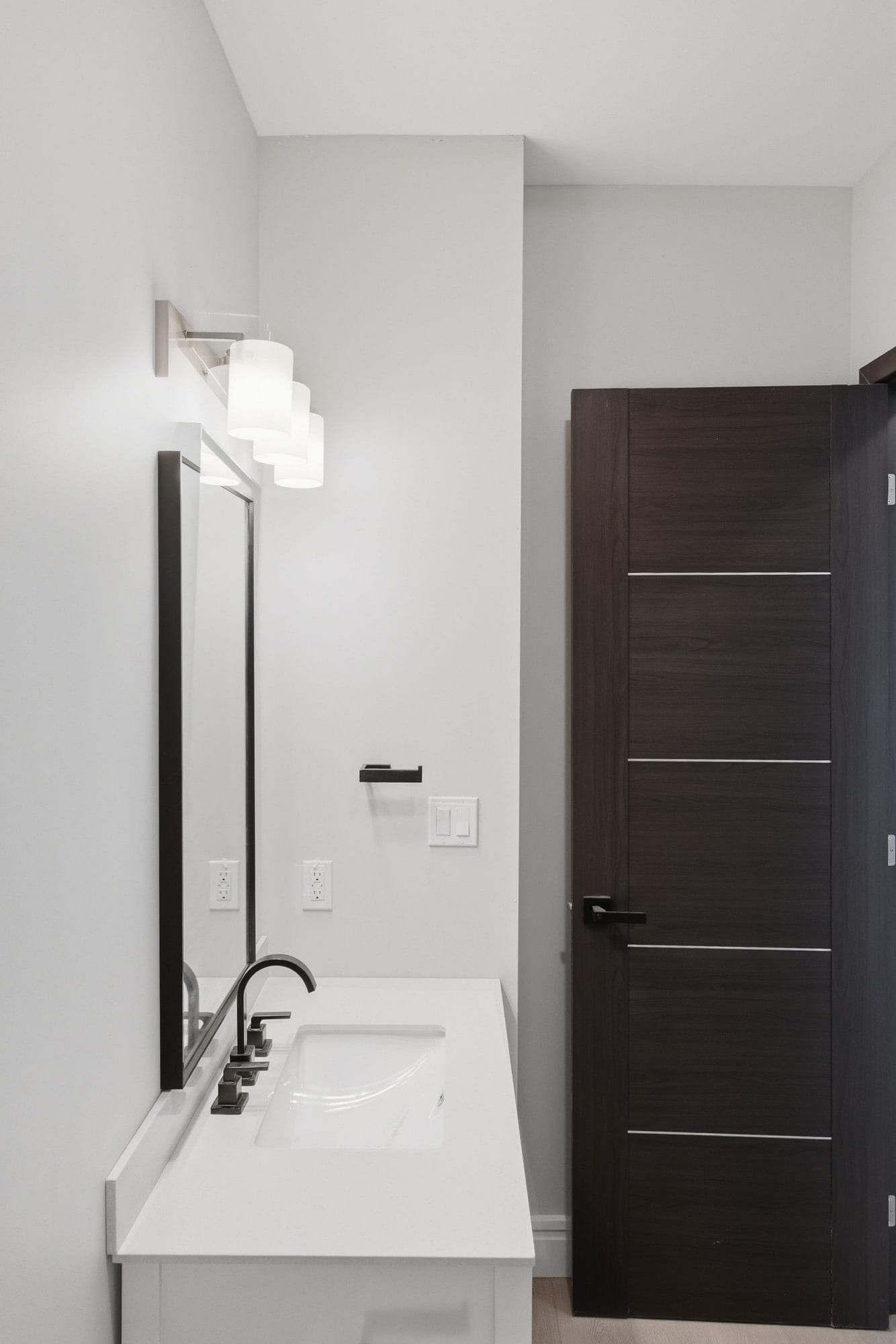 Washroom vanity with a quartz top, undermount sink and framed mirror